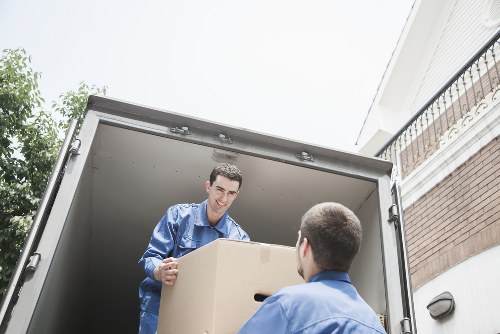 Movers carrying packed boxes from an Ilford property